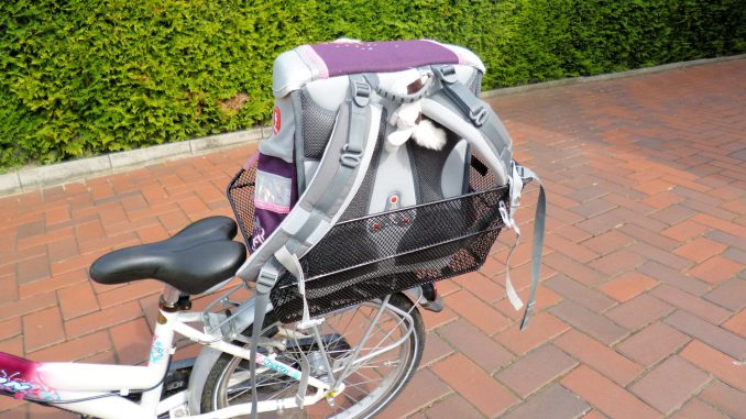 Kinderfahrrad mit Schultasche auf dem Schulweg